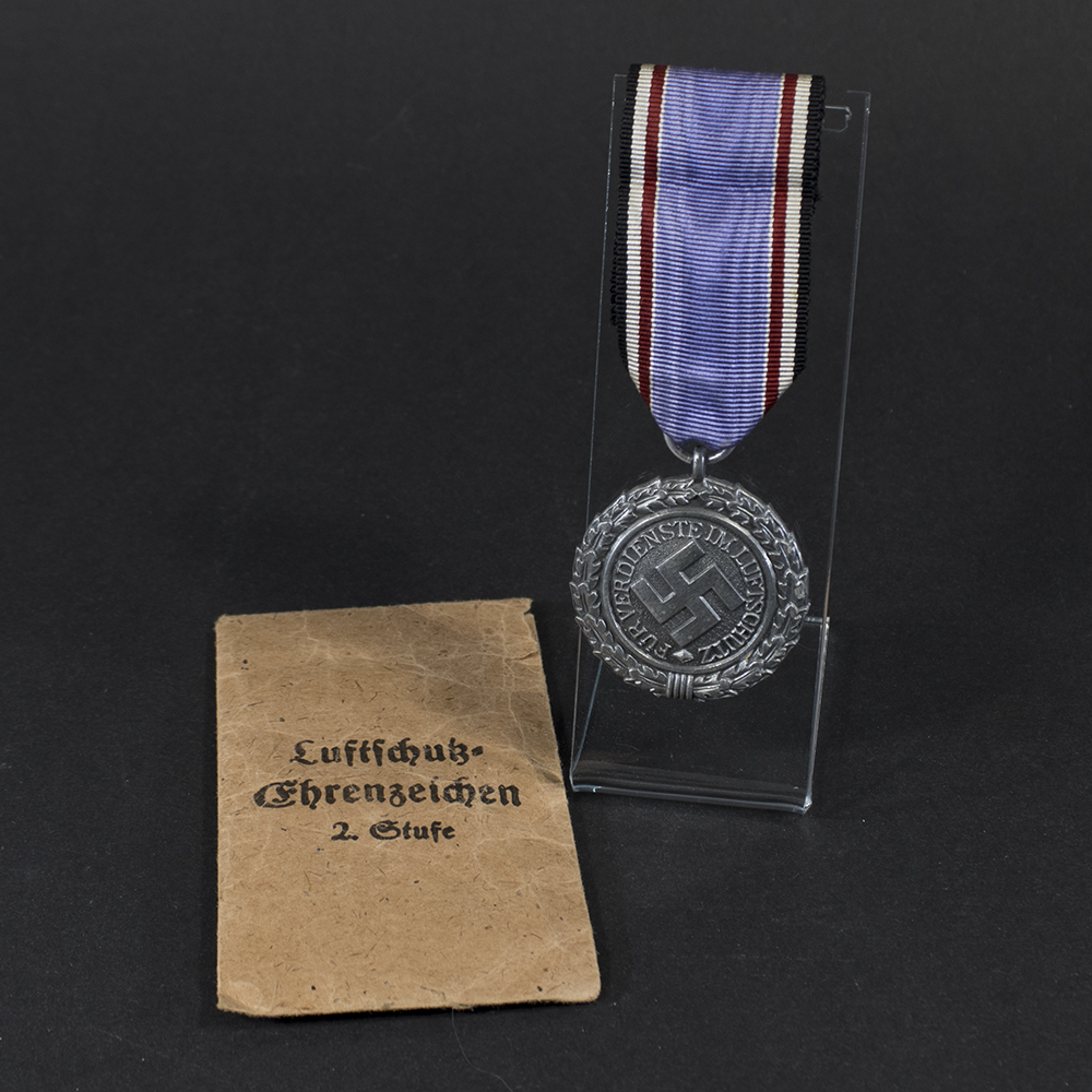 Overview of a WW2 German Luftschutz Medal 2nd Class displayed together with its original presentation bag.