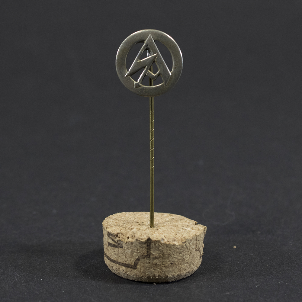 Overview of a World War II-era German SA (Sturmabteilung) membership pin displayed on a neutral background, showing its circular enamel design and overall condition.