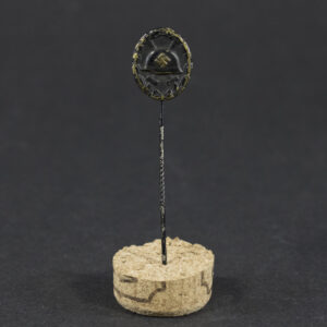 Overview of a WW2 German Black Wound Badge stick pin showing the complete badge and fastening pin