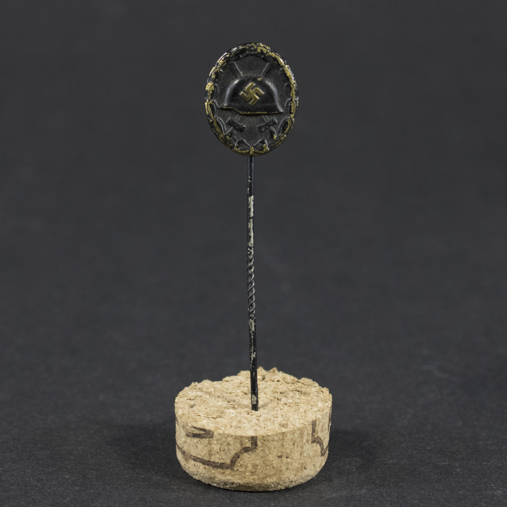 Overview of a WW2 German Black Wound Badge stick pin showing the complete badge and fastening pin