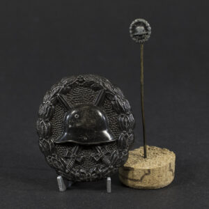 Overview of a German WW1 Wound Badge displayed together with the original stick pin.
