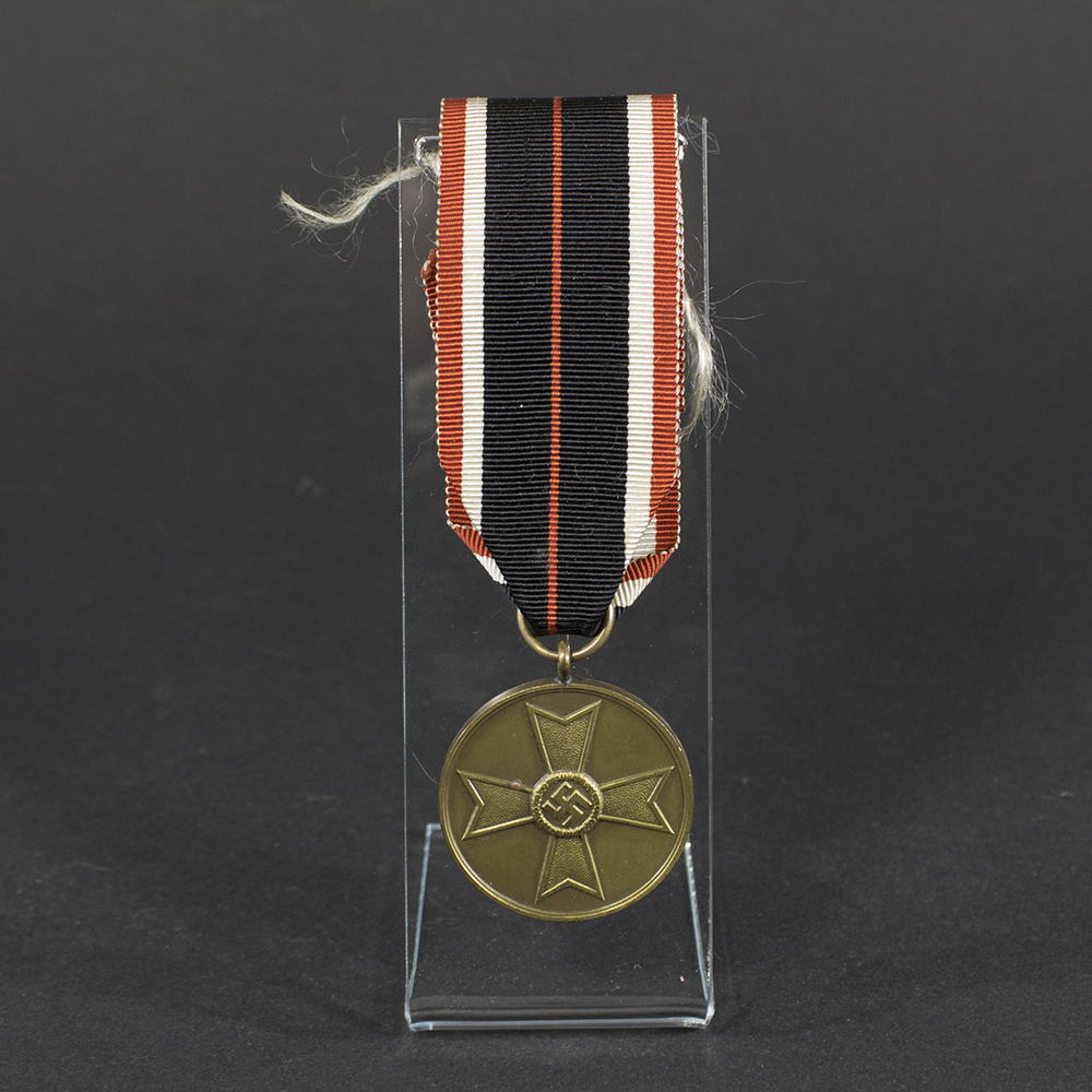 Overview of a World War II-era German War Merit Medal, shown with its ribbon, displaying the round bronze medal suspended from a striped ribbon against a neutral background.