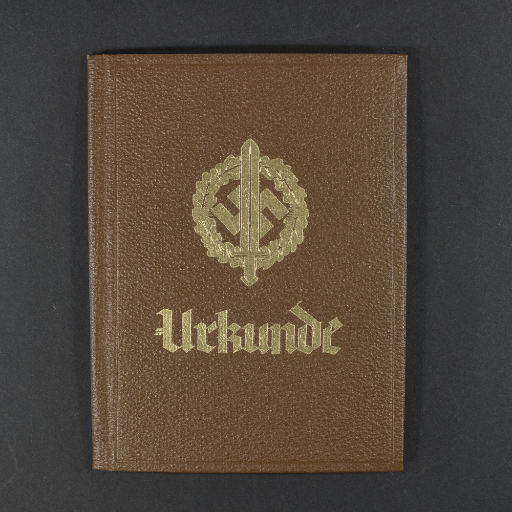 Front cover of a World War II-era German SA Sport Badge award booklet in brown color, featuring an image of the SA sports badge and the word “Urkunde” printed prominently.
