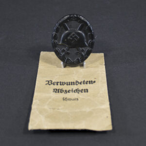 WW2 Black Wound Badge with maker marked bag overview showing badge and original packaging