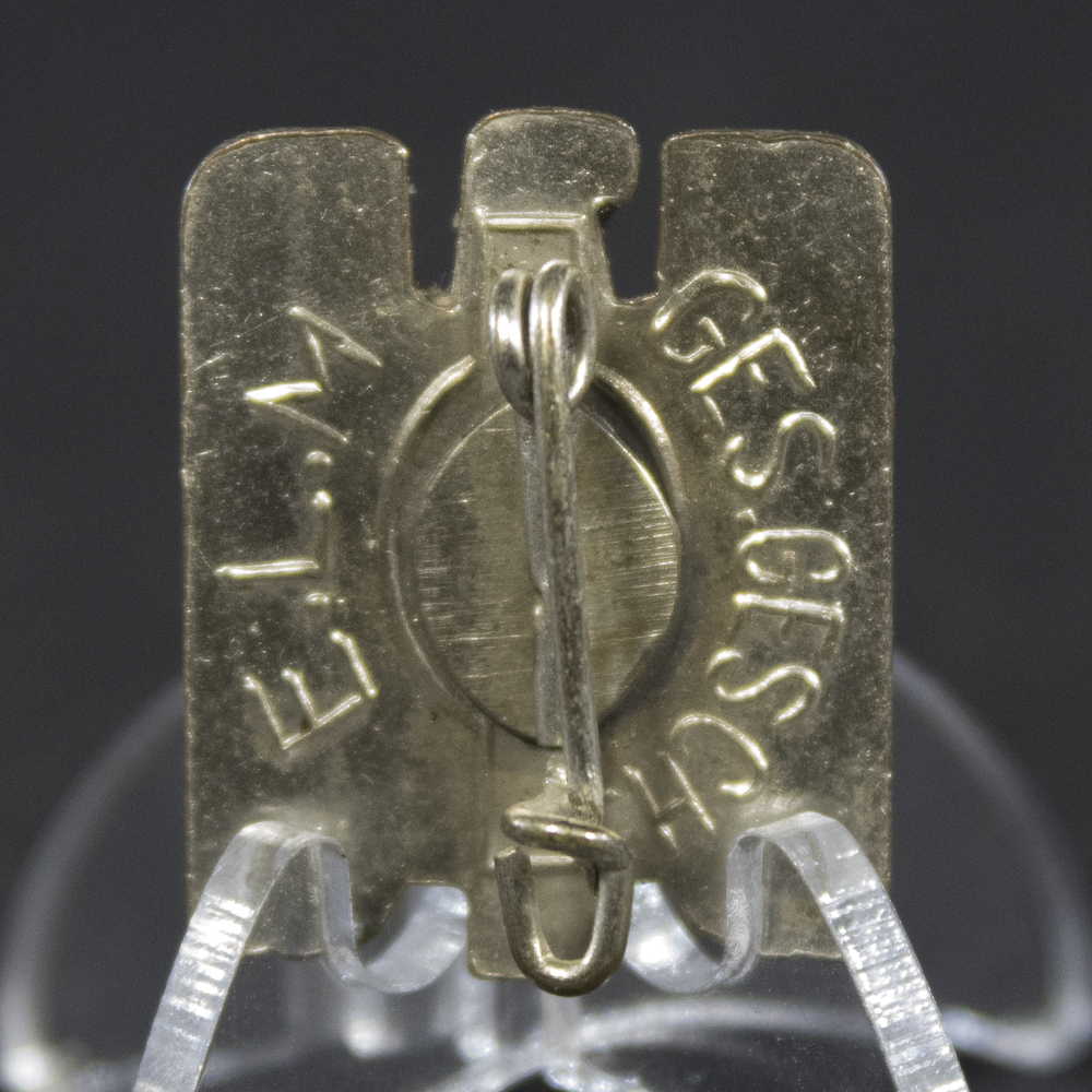 Detailed reverse view of the Nazi-era German Red Cross cap badge, showing the attachment hardware, fittings, and manufacturing details on the back.
