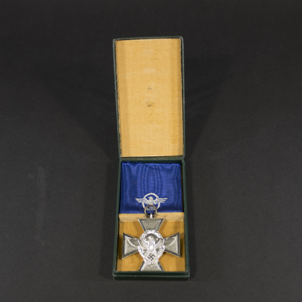 Overview of a German Police Long Service Award, 2nd Class (18 Years Service), displayed with its ribbon and presentation case.