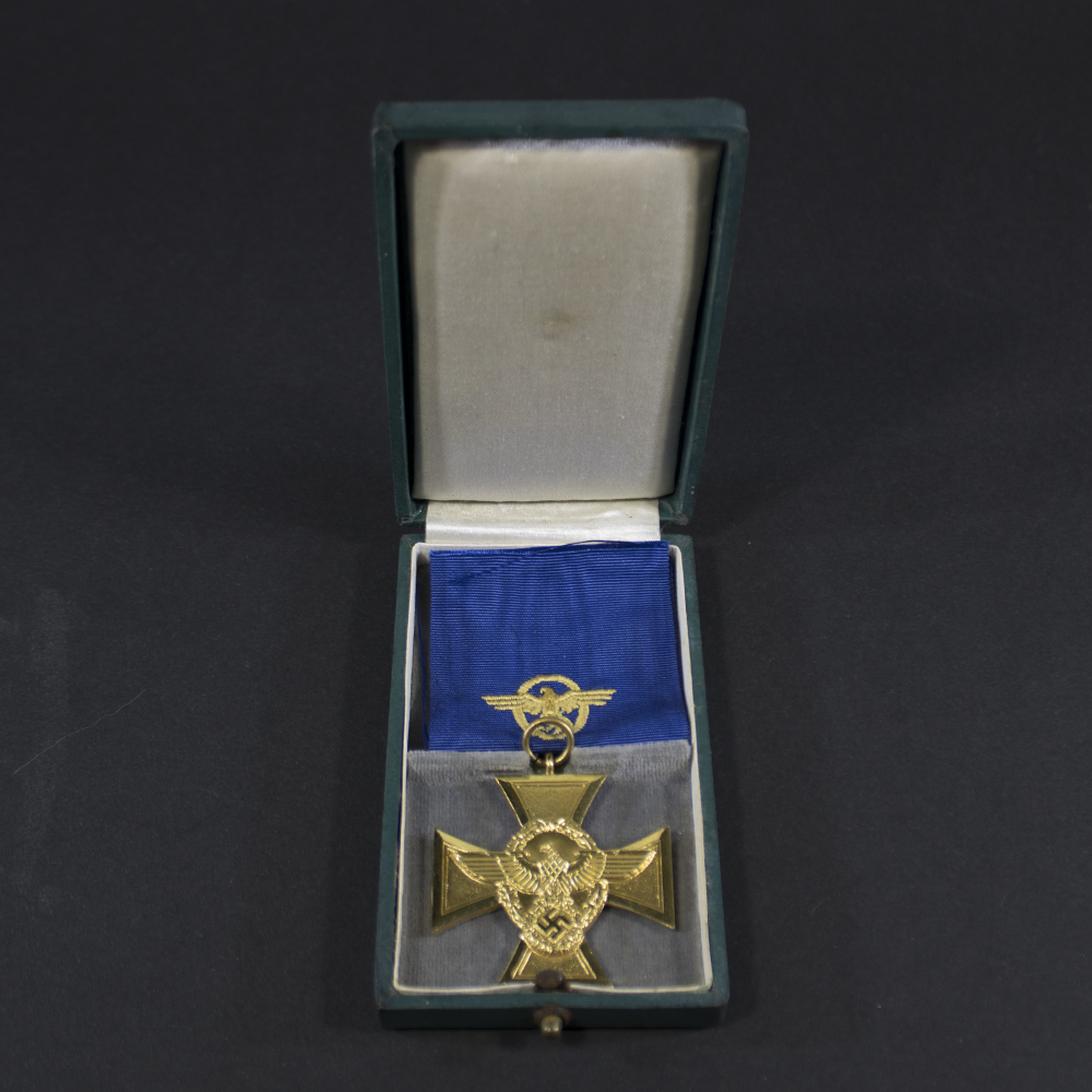 Overview of a German Police Long Service Award, 1st Class (25 Years Service), displayed with its ribbon and presentation case.