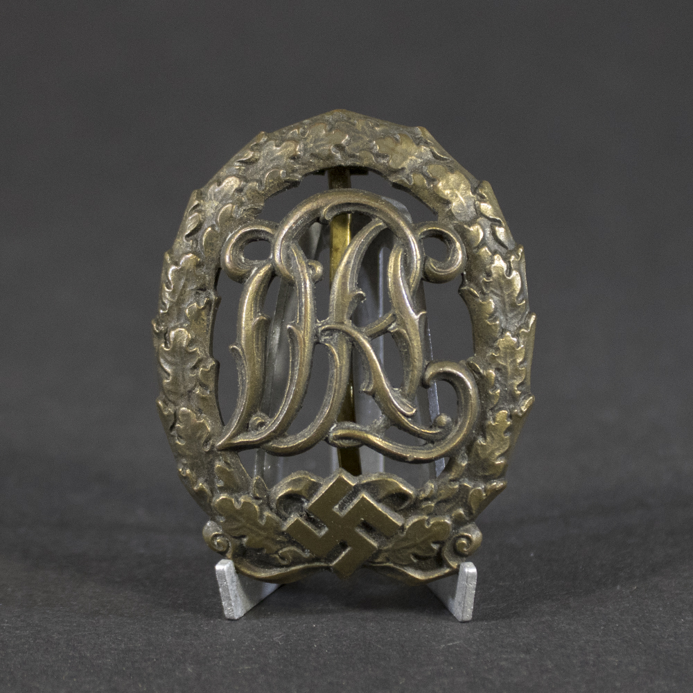 Overview of a WWII German Bronze DRL Sports Badge with original bronze finish and maker mark by Ernst Schneider.