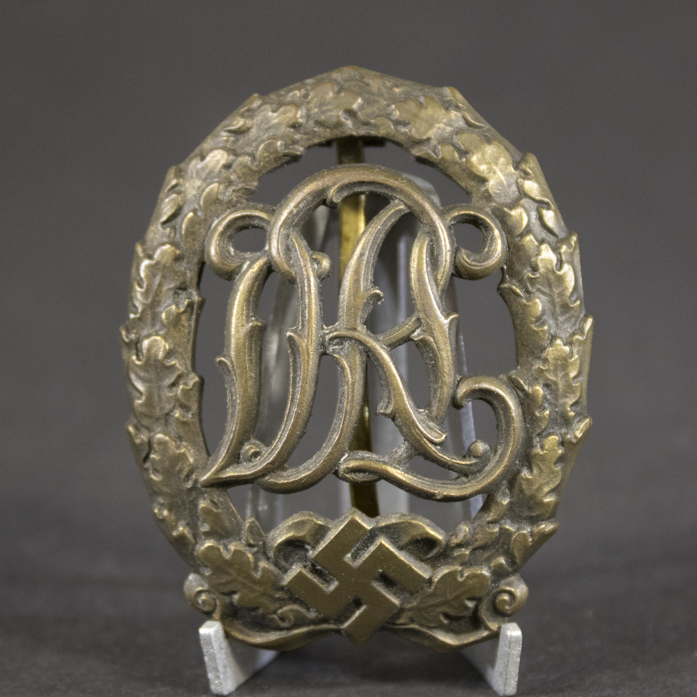 Close-up of the front of a German Bronze DRL Sports Badge showing the detailed wreath and sports emblem design.