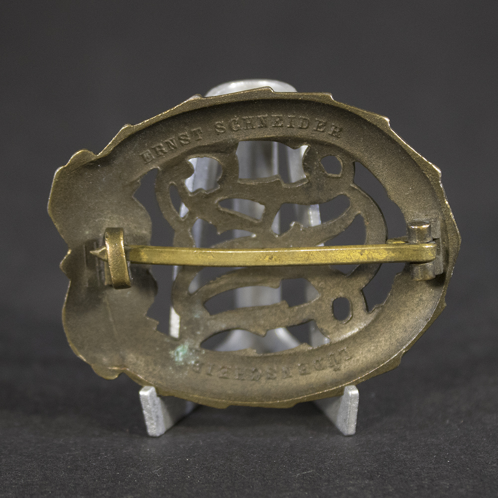 Detailed close-up of the Ernst Schneider maker mark on the reverse of a German Bronze DRL Sports Badge from World War II.