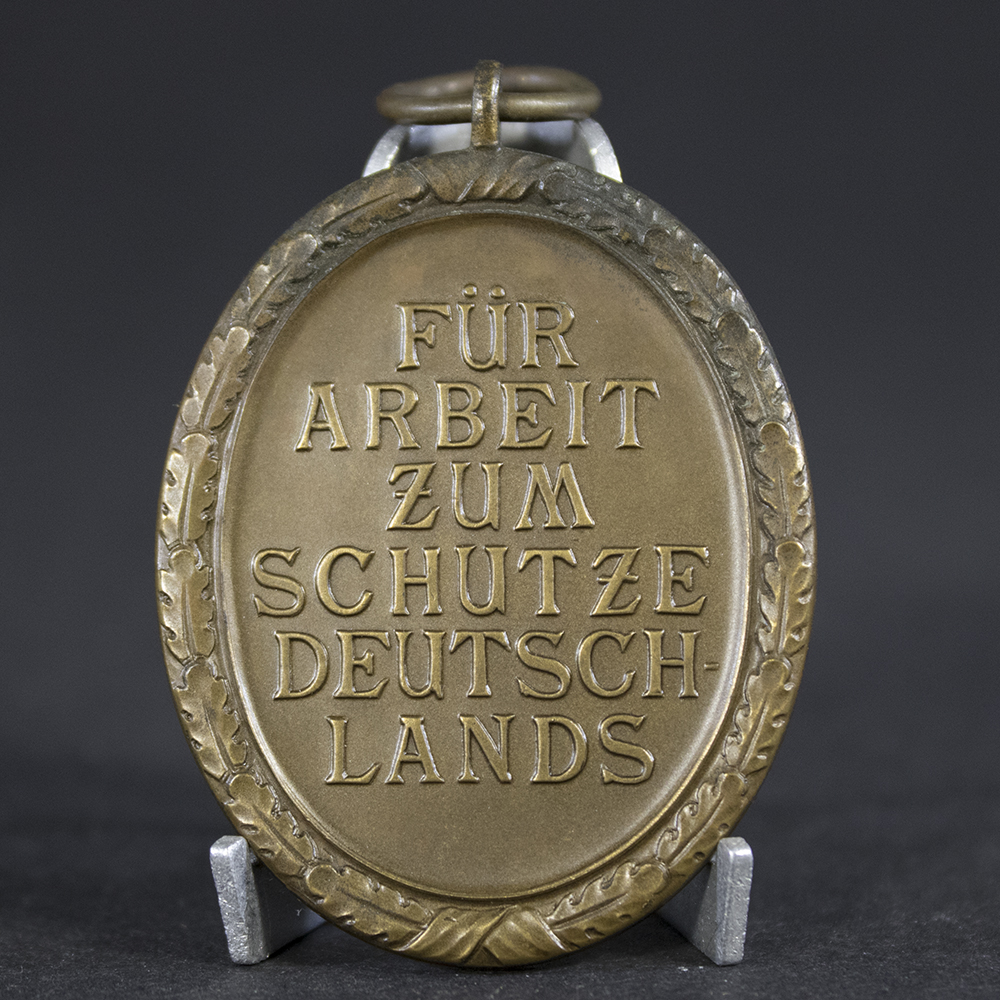 Close-up of the reverse of a German West Wall Medal displaying the original finish and construction details.