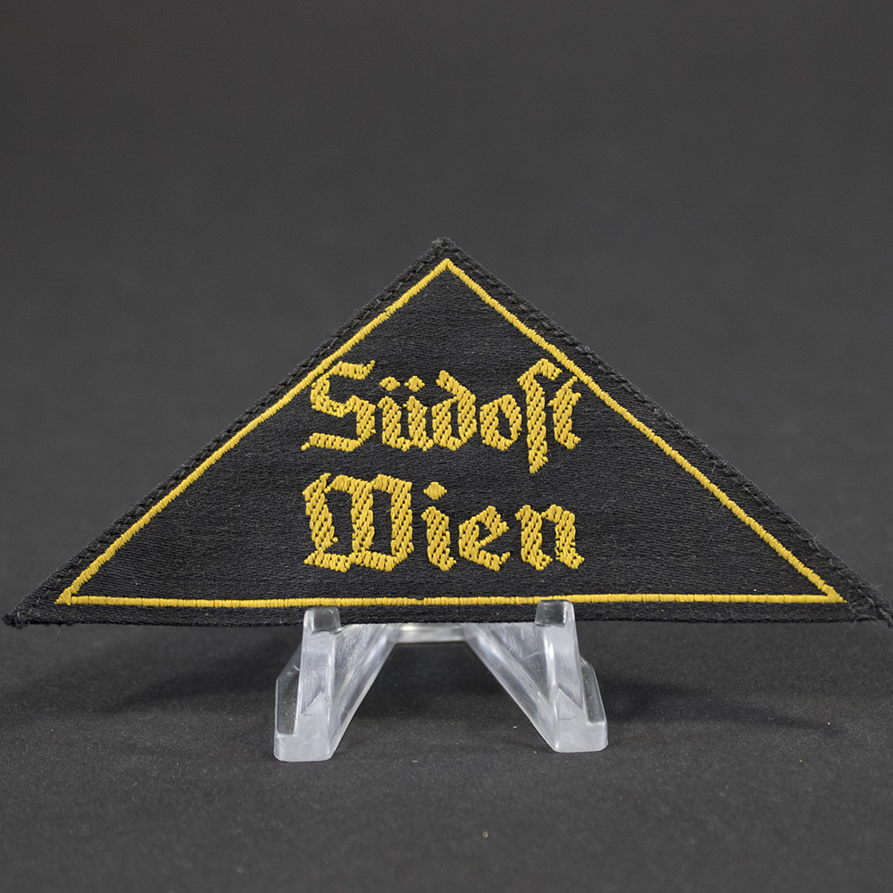 Close-up of the front of the HJ Gebietsdreieck “Südost Wien” patch, highlighting the embroidered text, fabric texture, stitching details, and edge finish of the triangular insignia.