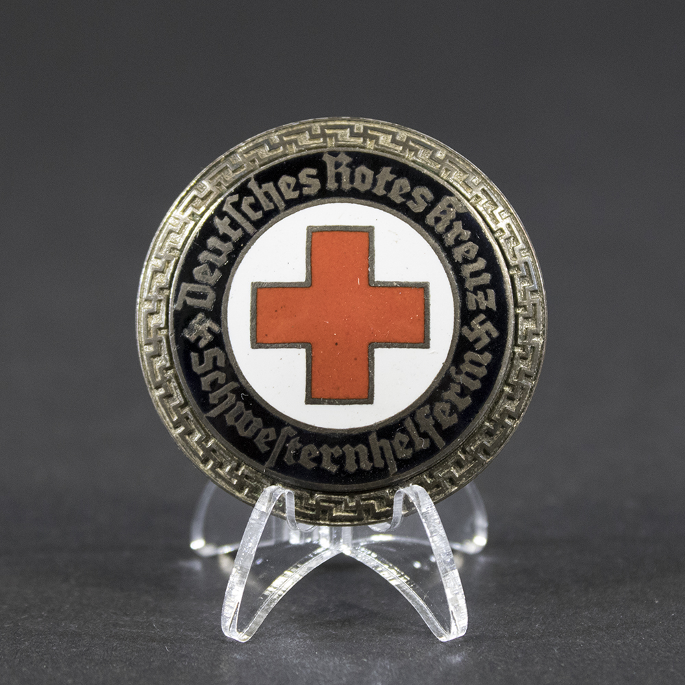 Overview of a DRK Schwesternhelferin brooch, shown in full view to display the complete design, shape, and overall condition of the nursing aide insignia.