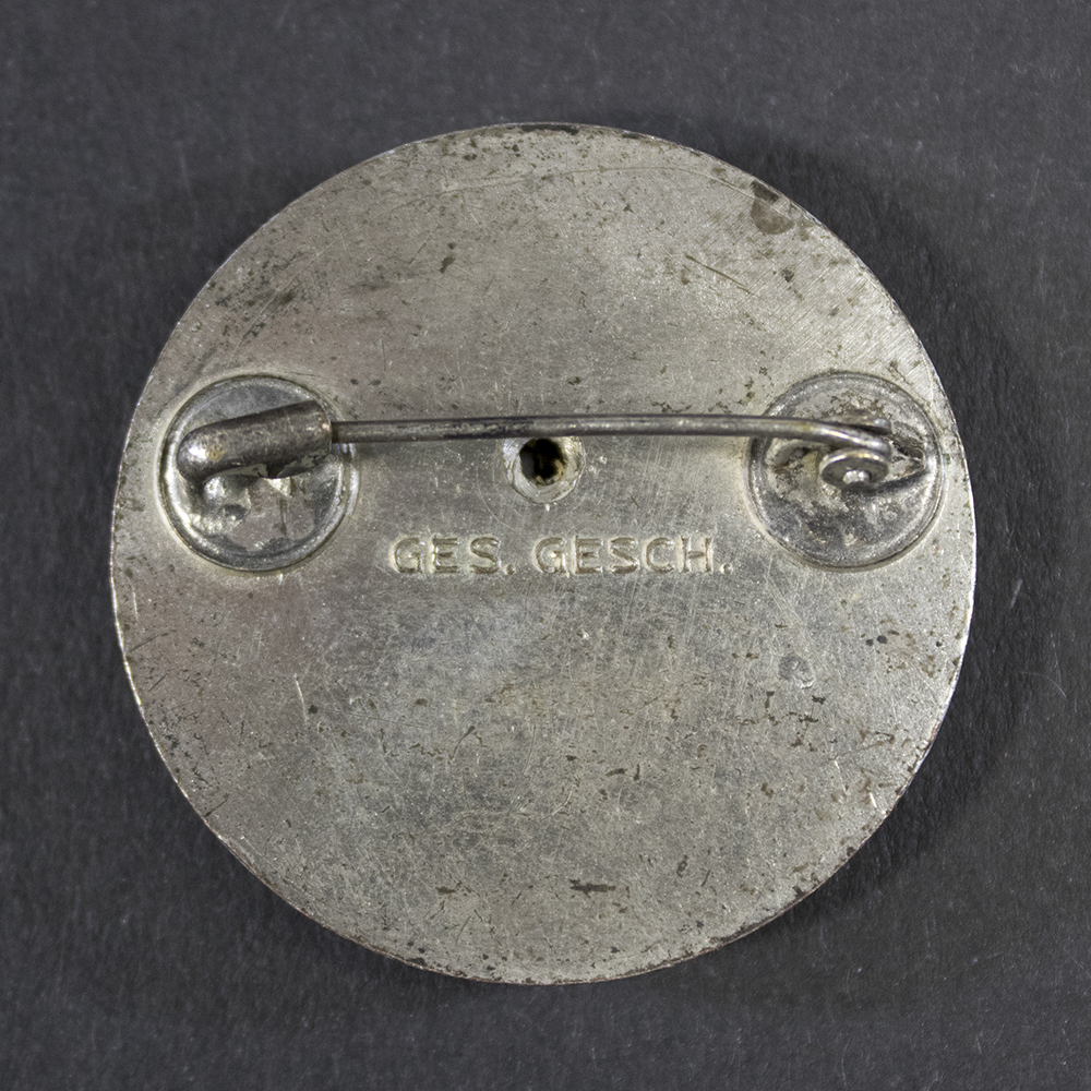 Close-up of the reverse side of the DRK Schwesternhelferin brooch, showing the pin assembly, fastening mechanism, any maker or manufacturer markings, and the condition of the reverse surface.