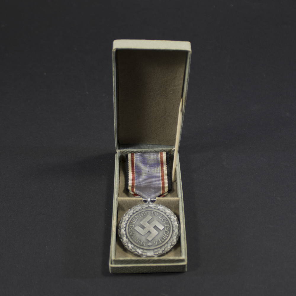 Overview of a cased World War II German Air Defence Medal 2nd Class, displaying the medal nestled inside its fitted presentation case with both items shown together.