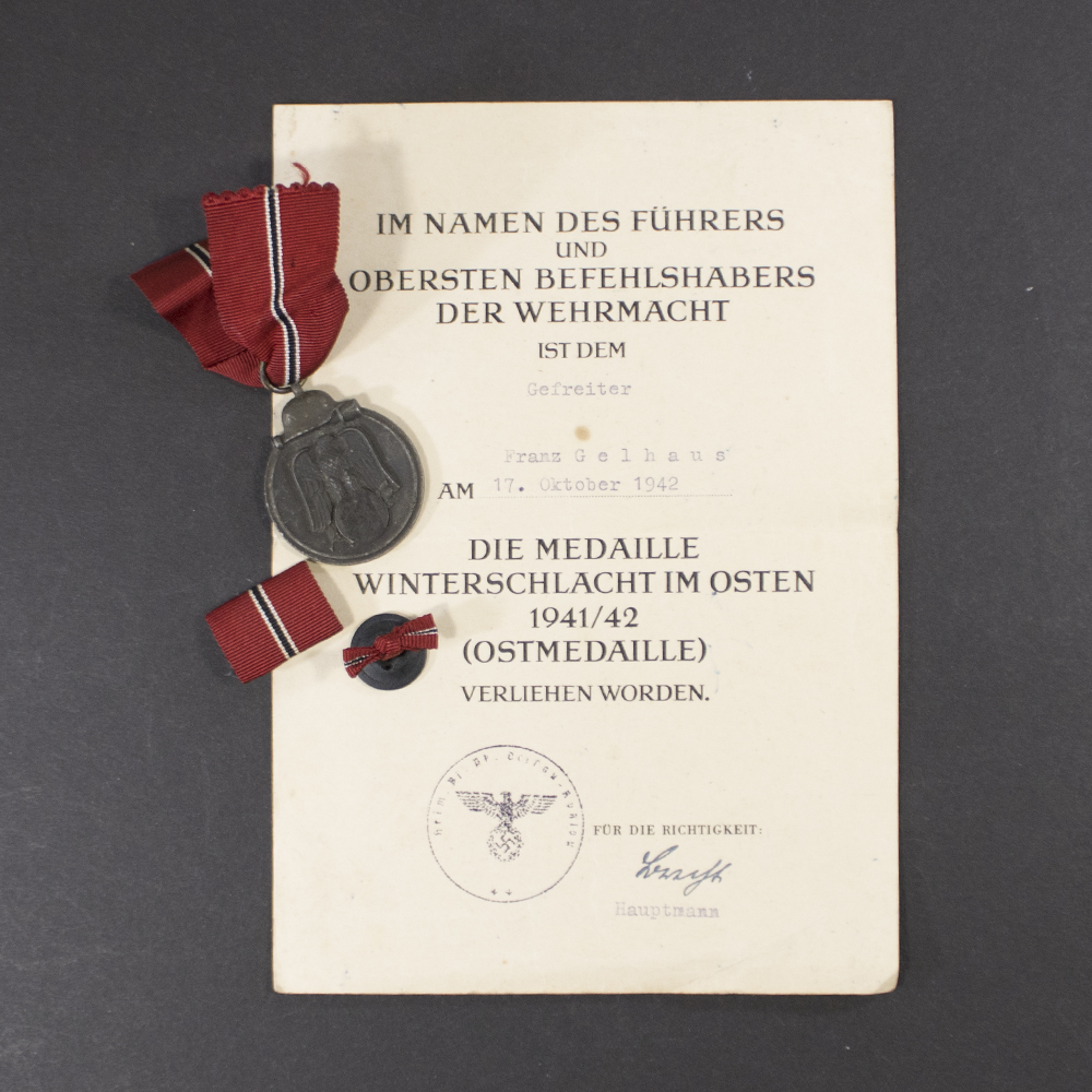 Eastern Front Medal set with original award document, showing the medal, ribbon, and accompanying wartime certificate.