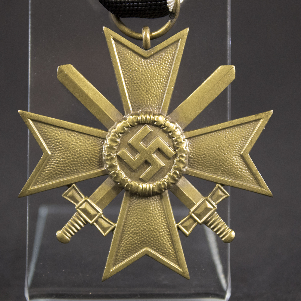 Close-up of the obverse of a War Merit Cross with Swords, 2nd Class, showing the detailed pebbled finish, central wreath, and crossed swords between the cross arms.