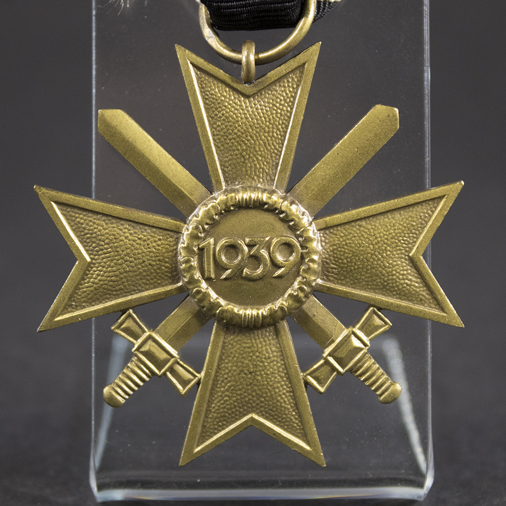 Close-up of the reverse of a War Merit Cross with Swords, 2nd Class, displaying the plain reverse design, suspension ring, and bronze-colored finish.