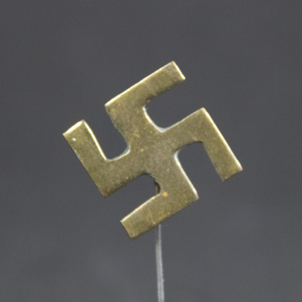 Close-up front view of an original Third Reich Swastika Stickpin displaying crisp details, period craftsmanship, and worn silver finish over tombak.