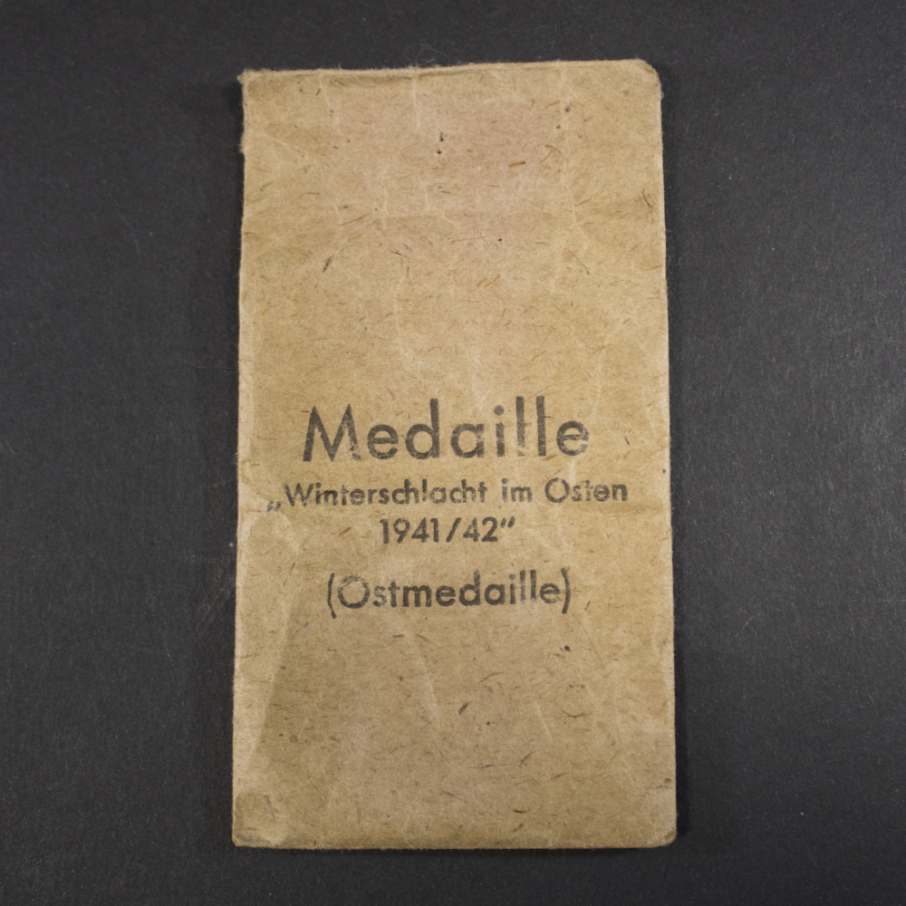 Front view of the original Eastern Front Medal issue bag with printed award designation and period paper construction.