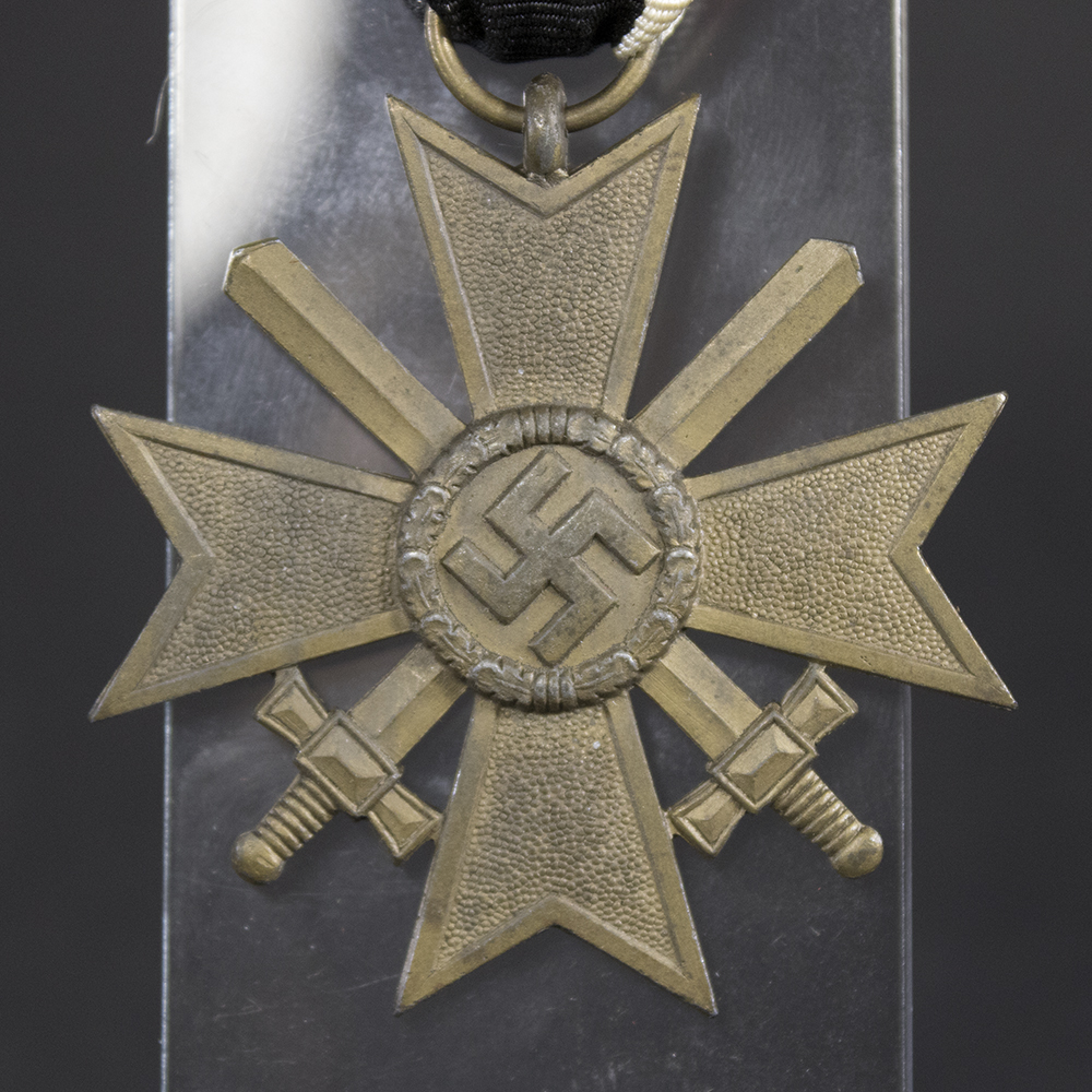 Close-up obverse view of the War Merit Cross with Swords, displaying the detailed cross design, wreath, and crossed swords.