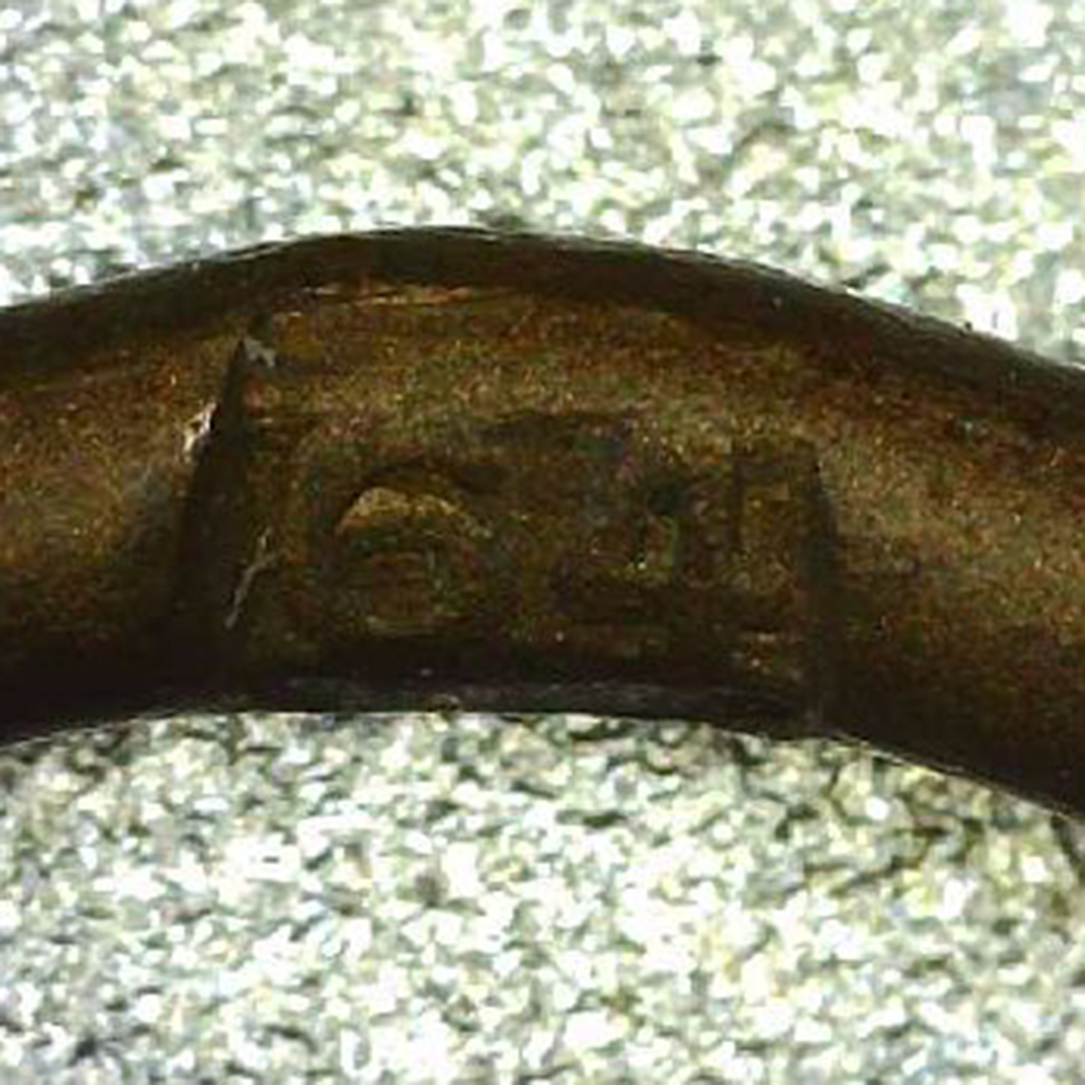 Close-up of the “64” maker mark stamped in the ring of the War Merit Cross with Swords, identifying the manufacturer as Steinhauer & Lück.
