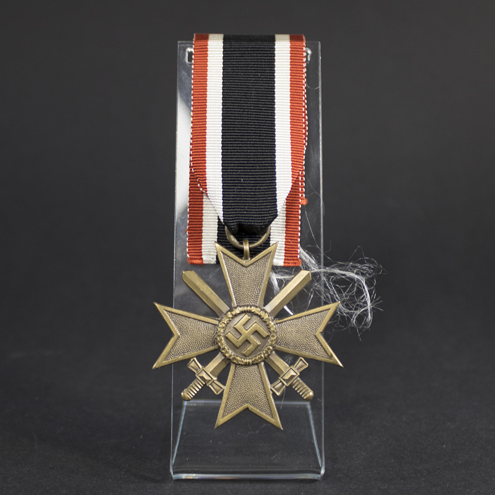 Original War Merit Cross with Swords showing the complete decoration with ribbon, featuring authentic wartime construction and finish.