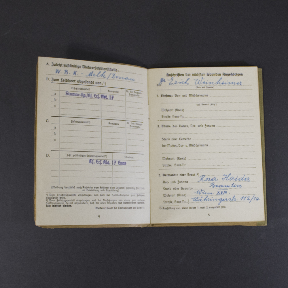 Interior pages of a German WWII Soldbuch displaying the soldier's personal information, physical description, official unit stamp, signature, and verification entries.