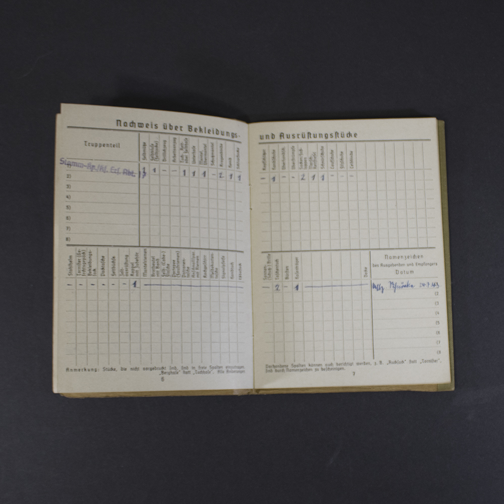 Inside pages of a German WWII Soldbuch containing records of issued clothing and equipment, with official entries documenting military gear provided to the soldier.