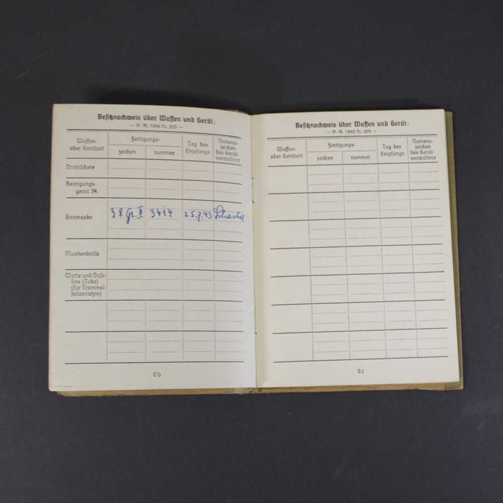 Interior pages of a German WWII Soldbuch displaying weapon and equipment records, including issued gas mask information, serial numbers, dates, and handwritten verification entries.