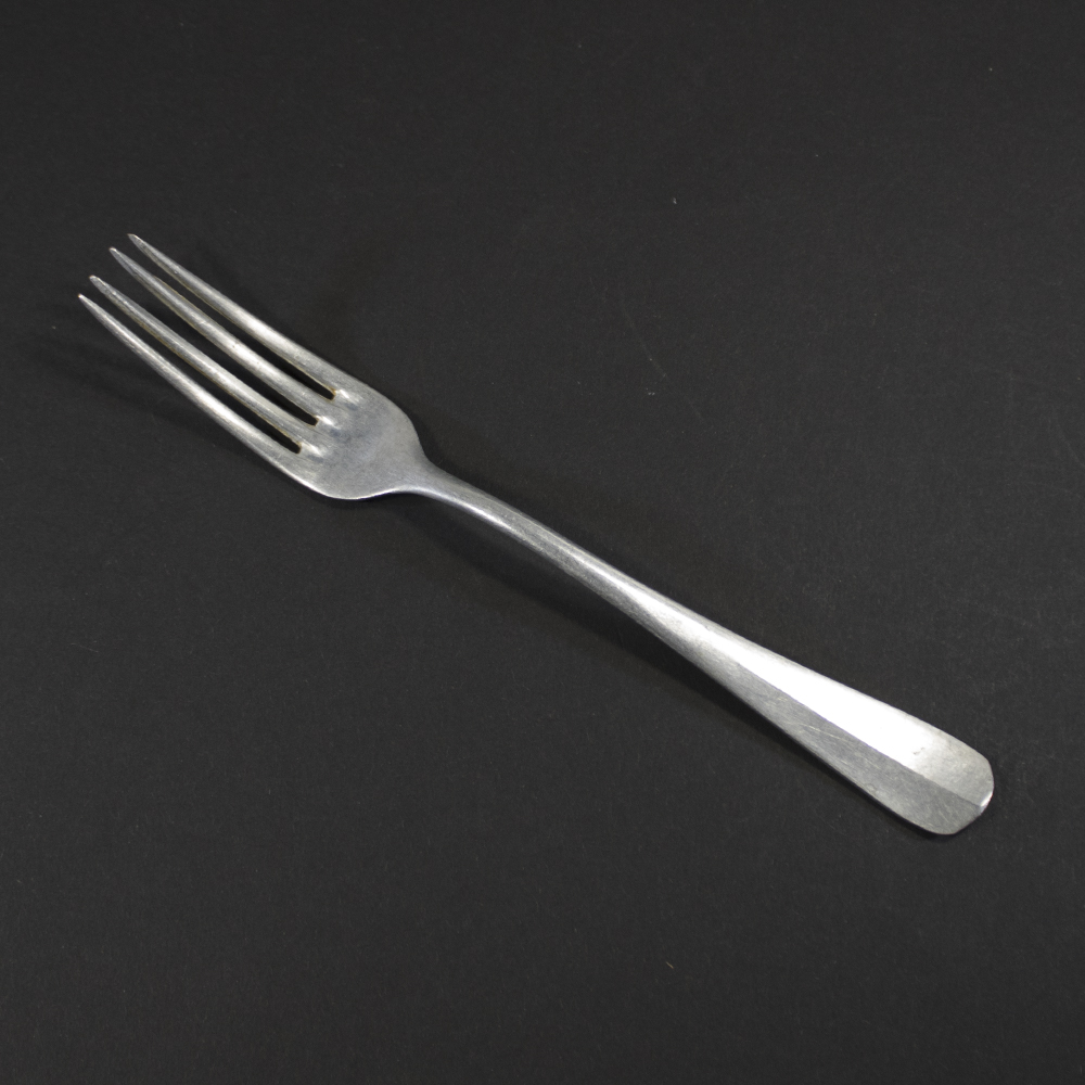 Front view of a WW2 German Kriegsmarine aluminum canteen fork on a dark background.
