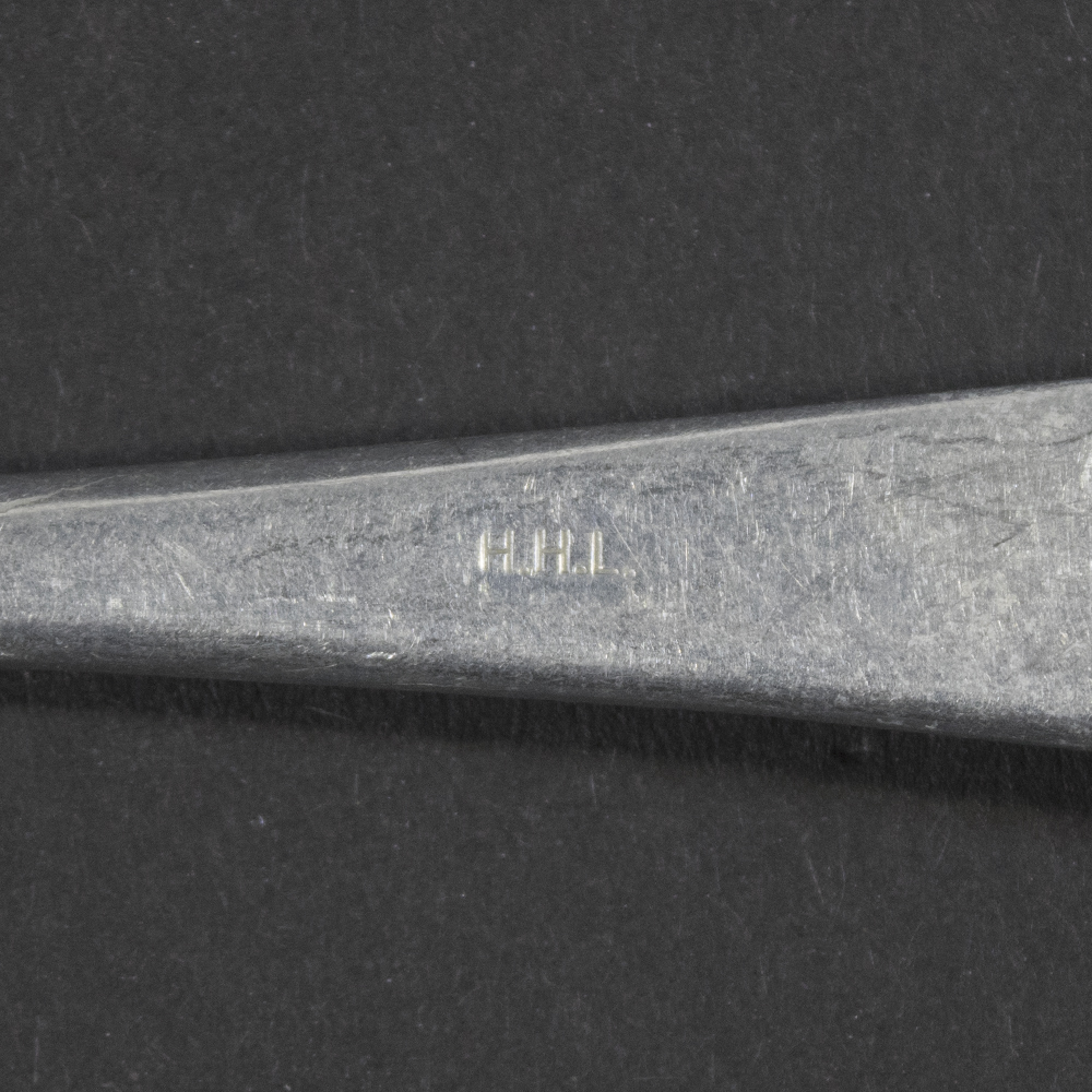 Close-up of the H.H.L. manufacturer code stamp on the reverse neck of the aluminum fork.