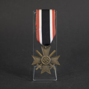 Front view of a WW2 German War Merit Cross 2nd Class with Swords, featuring a pebbled bronze Maltese cross, crossed swords, and central swastika attached to its original red, white, and black ribbon on a clear display stand.