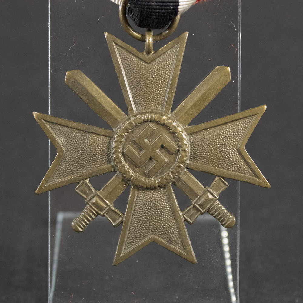 Detailed close-up of the front of the Bronze War Merit Cross showing the central swastika surrounded by an oak leaf wreath and crossed swords.
