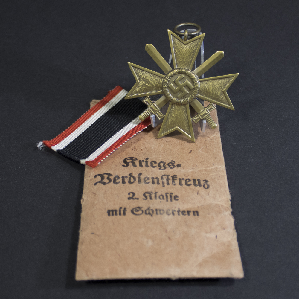 WWII German War Merit Cross 2nd Class with Swords set resting on its paper packet